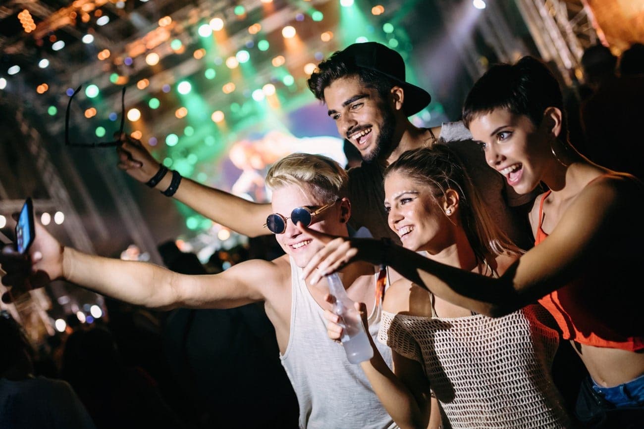 Friends taking a photo together at a festival | Floyd's Barbershop