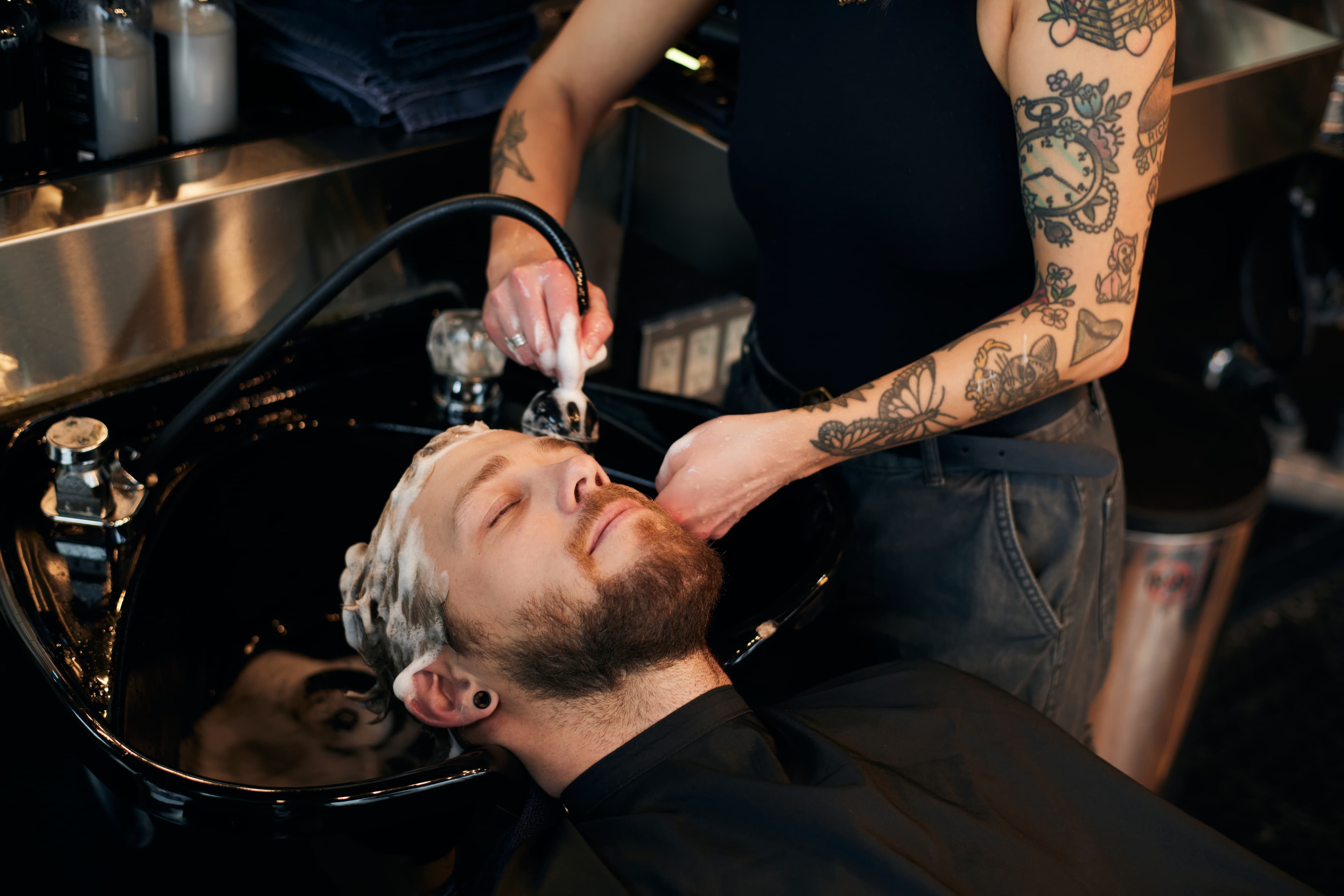 Man getting his hair shampooed during a haircut at Floyd's Barbershop