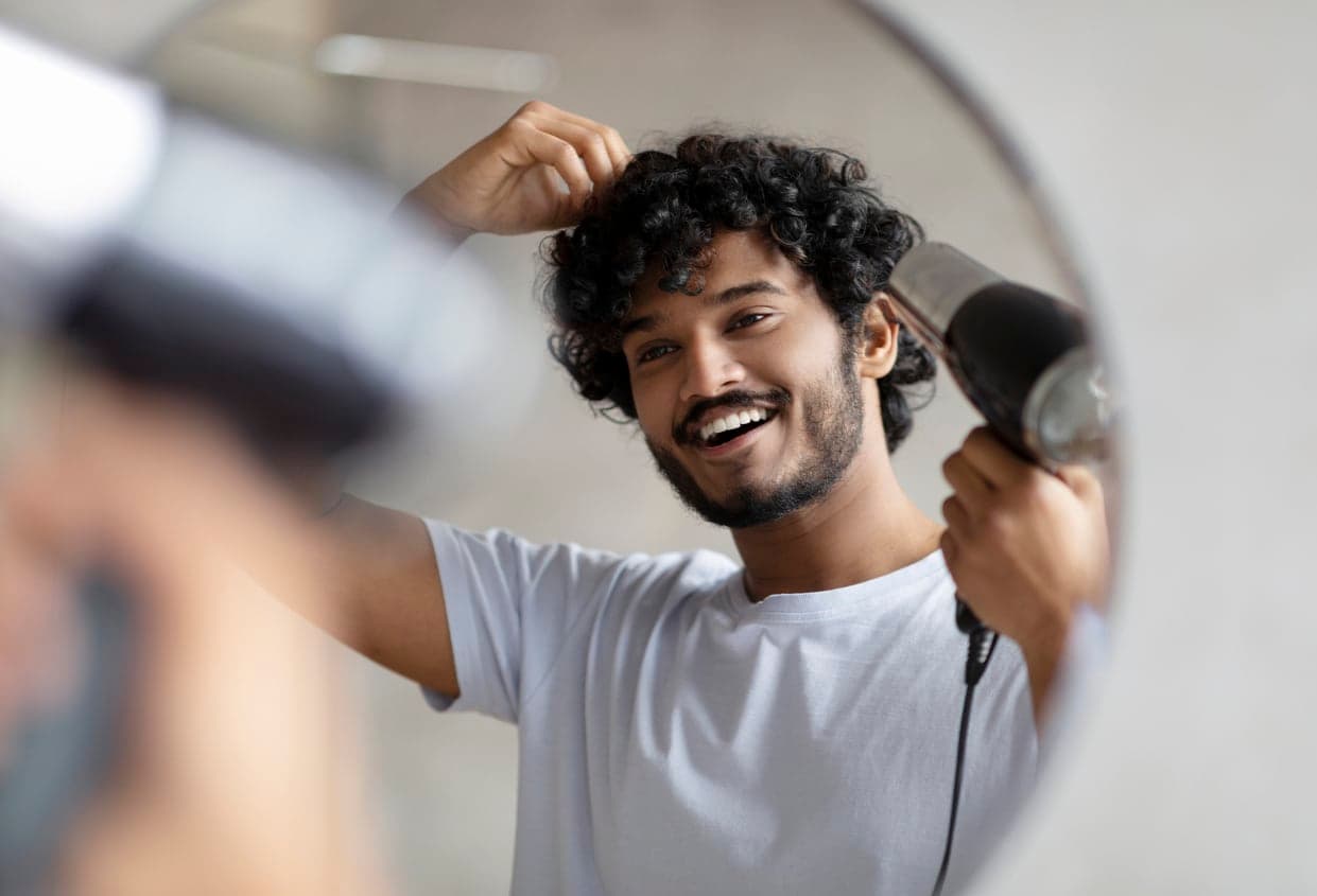 Man blow drying his hair | Floyd's Barbershop