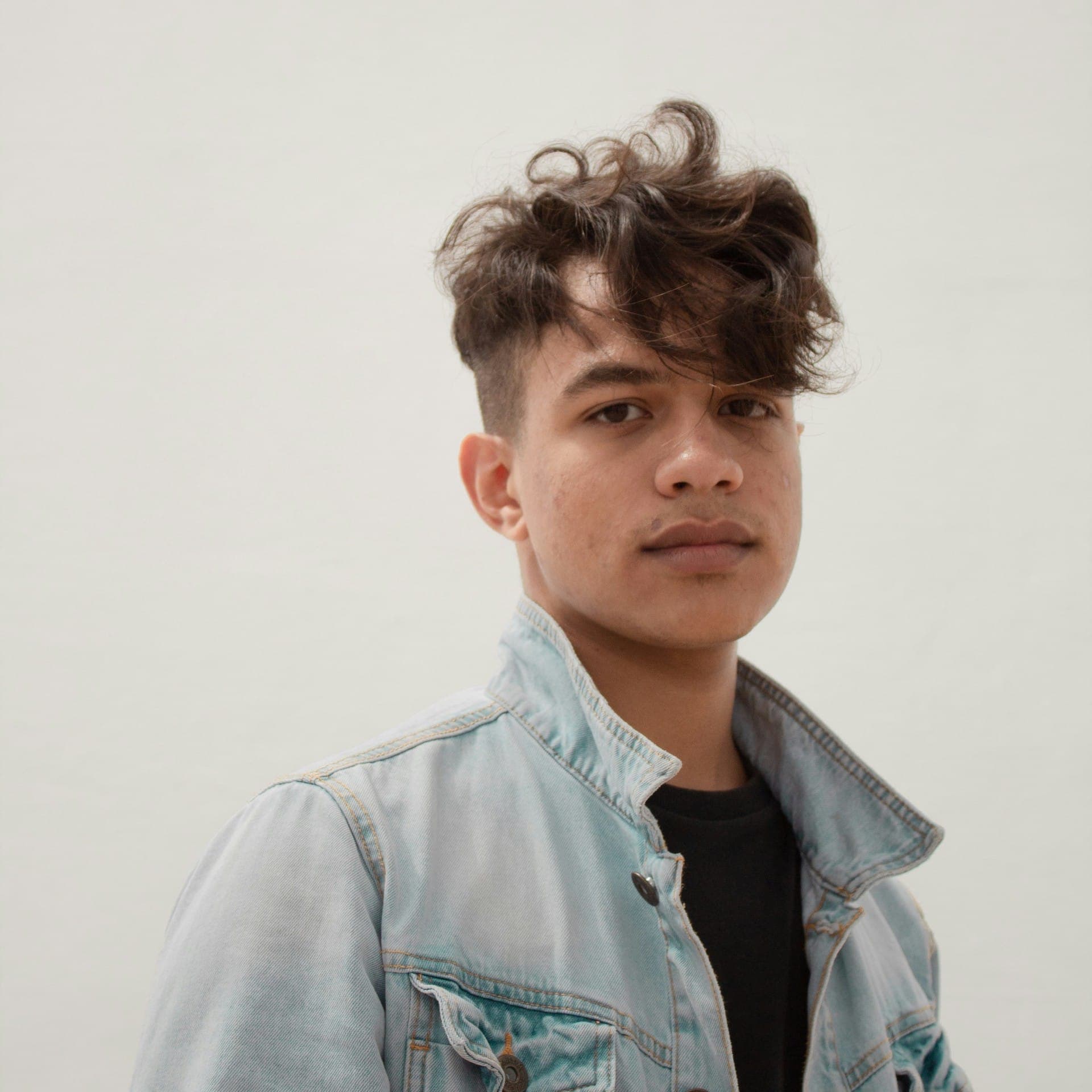 A young teen boy with a messy fringe haircut by Floyd's Barbershop.