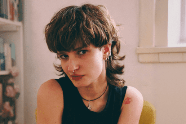 A young brunette woman wearing a modern mullet haircut from Floyds Barbershop.