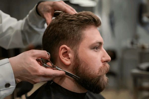 A man getting his beard shaped up from Floyds Barbershop
