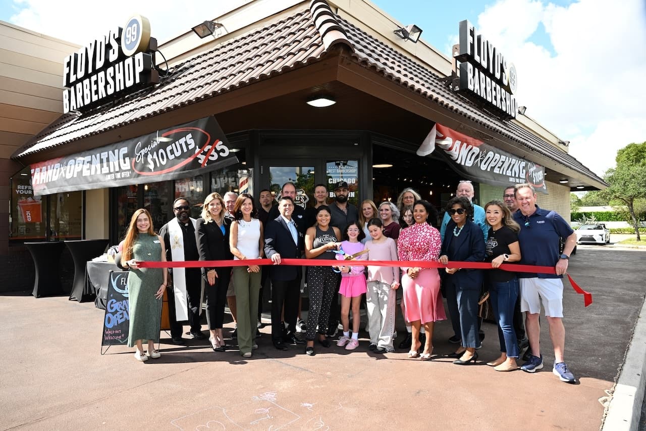 A crowd of people in front of the grand opening of a new Floyd's Barbershop.